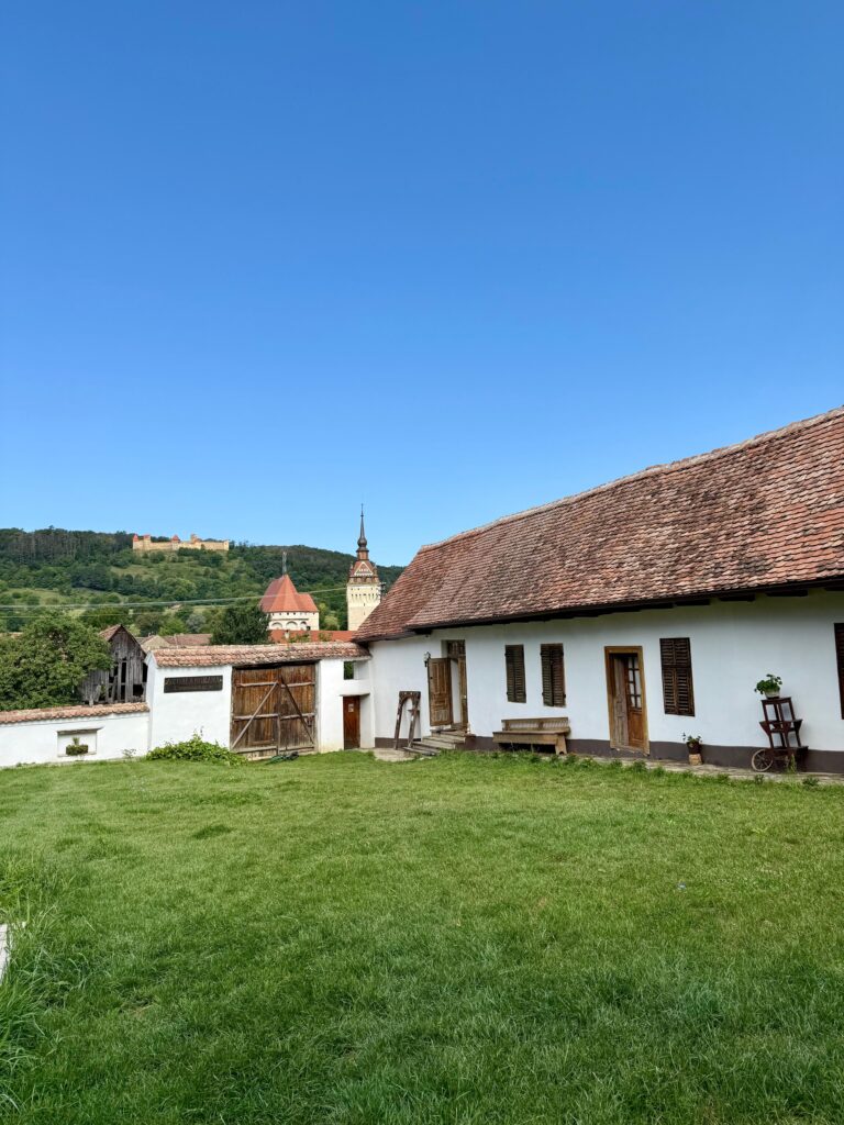 Vedere din curtea cazării Castle View Saschiz, sat săsesc Saschiz, cu Cetatea Țărănească și Biserica Fortificată Saschiz în spate