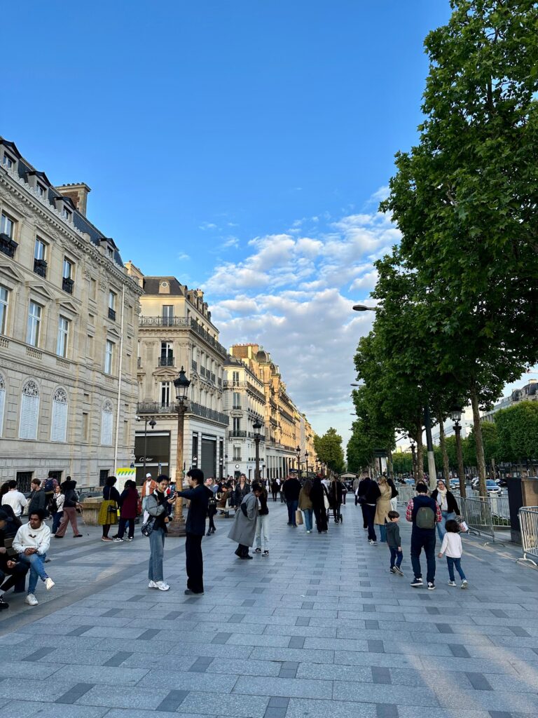 Champs-Élysées Paris, bulevard iconic cu magazine, trafic urban și vedere spre Arcul de Triumf